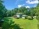 Expansive backyard view featuring lush lawn, mature trees, and a charming deck area at 1209 Ravens Point Cir, Raleigh, NC 27614