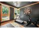 Well-lit exercise room with large windows, hardwood floors, and modern fitness equipment for a healthy lifestyle at 1209 Ravens Point Cir, Raleigh, NC 27614