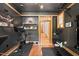 Modern exercise room featuring sleek design, dark walls, hardwood accents, and state-of-the-art fitness equipment at 1209 Ravens Point Cir, Raleigh, NC 27614