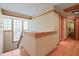 Bright hallway with hardwood floors, unique glass block window, and warm wooden trim accents at 1209 Ravens Point Cir, Raleigh, NC 27614