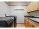 Efficient laundry room with modern washer and dryer, ample counter space, and wooden cabinets at 1209 Ravens Point Cir, Raleigh, NC 27614