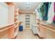 Spacious walk-in closet features wood shelving and built-in storage for optimal organization and convenience at 1209 Ravens Point Cir, Raleigh, NC 27614