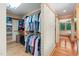 Walk-in closet with wood floors, open shelving, and hanging rods for ample storage and easy organization at 1209 Ravens Point Cir, Raleigh, NC 27614