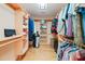 Well-organized walk-in closet featuring custom wood shelving and hanging rods for ample storage and organization at 1209 Ravens Point Cir, Raleigh, NC 27614