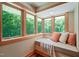 Inviting window seat surrounded by nature views, offering a cozy spot with comfortable pillows and soft light at 1209 Ravens Point Cir, Raleigh, NC 27614