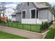 View of gray home's backyard featuring a green lawn, black fence, and a charming playset at 1212 Gunnison Pl, Raleigh, NC 27609