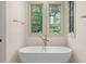 Bathroom showcasing a luxurious soaking tub with nature views and designer fixtures at 1212 Gunnison Pl, Raleigh, NC 27609