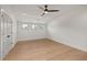 Bright bedroom with hardwood floors, three windows, ceiling fan, and white trim at 1212 Gunnison Pl, Raleigh, NC 27609