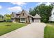 Spacious home with a side-entry garage, long driveway, stone and siding details, and landscaped front yard at 1212 Gunnison Pl, Raleigh, NC 27609