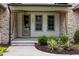 Inviting entryway with a custom wood door, stone accents, and a landscaped garden bed at 1212 Gunnison Pl, Raleigh, NC 27609