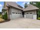 Attached three-car garage offering ample parking space with a concrete driveway and stone accent walls at 1212 Gunnison Pl, Raleigh, NC 27609