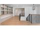 Open hallway with hardwood floors, custom built-ins, and decorative staircase at 1212 Gunnison Pl, Raleigh, NC 27609