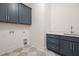 Modern laundry room with navy cabinets and a marble-look tile floor at 1212 Gunnison Pl, Raleigh, NC 27609