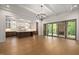 Open concept living room with an adjacent kitchen, hardwood floors, and access to an outdoor patio at 1212 Gunnison Pl, Raleigh, NC 27609