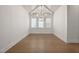 Well-lit living room featuring a vaulted ceiling, hardwood floors, and a stylish chandelier at 1212 Gunnison Pl, Raleigh, NC 27609