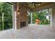 Covered outdoor patio featuring a stone fireplace and a view of the backyard at 1212 Gunnison Pl, Raleigh, NC 27609