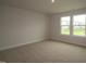 Bright bedroom featuring neutral walls, plush carpet, and windows that flood the room with natural light at 1218 Tredenham Way, Durham, NC 27703
