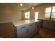 Eat-in kitchen island featuring storage space, stone countertops, and modern pendant lighting at 1218 Tredenham Way, Durham, NC 27703
