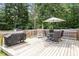 Large wooden deck complete with grill, dining table, patio umbrella and plenty of chairs for lounging at 1304 Castlebay Rd, Durham, NC 27703