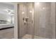 Glass-enclosed shower with tiled walls, mosaic floor and a view into a bedroom in this updated bathroom at 1304 Castlebay Rd, Durham, NC 27703