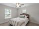 Cozy bedroom features a neutral color palette, plush carpet, ceiling fan, and bright windows at 1304 Castlebay Rd, Durham, NC 27703