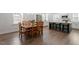 Open dining room and kitchen area featuring hardwood floors, an island with bar seating, and stainless steel appliances at 1304 Castlebay Rd, Durham, NC 27703