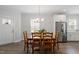 Cozy dining room with wood table, stainless fridge, and a view of the entry door and windows at 1304 Castlebay Rd, Durham, NC 27703