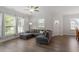 Spacious living room with hardwood floors, a gray sectional sofa, and large windows providing ample natural light at 1304 Castlebay Rd, Durham, NC 27703