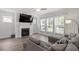 Bright living room featuring a fireplace, large windows, hardwood floors, and a comfortable gray sofa at 1304 Castlebay Rd, Durham, NC 27703