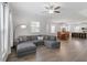Open-concept living room with hardwood floors, a gray sectional sofa, leading to a dining area and kitchen at 1304 Castlebay Rd, Durham, NC 27703