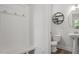 Clean powder room with a pedestal sink, round mirror, and a decorative wall shelf at 1304 Castlebay Rd, Durham, NC 27703