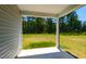 Covered back porch with view of backyard with trees at 1444 Heron Pond St, Raleigh, NC 27604