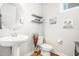 Stylish powder room with a pedestal sink, decorative shelving, and modern fixtures, perfect for guests at 1502 Spring Overlook Ln, Hillsborough, NC 27278