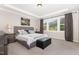 Calm primary bedroom features large windows, tray ceiling, carpet, and soft, neutral colors at 1502 Spring Overlook Ln, Hillsborough, NC 27278