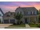 Beautiful two-story home showcasing a manicured lawn and welcoming front porch under a colorful sky at 1502 Spring Overlook Ln, Hillsborough, NC 27278