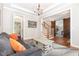 Bright living room featuring hardwood floors, a comfortable sofa, and a staircase in the background at 1502 Spring Overlook Ln, Hillsborough, NC 27278