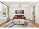 Inviting living room features a cozy sofa with orange pillows, hardwood flooring, and modern decor at 1502 Spring Overlook Ln, Hillsborough, NC 27278