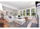 Inviting living room featuring a large sectional, hardwood floors, and abundant natural light from large windows at 1502 Spring Overlook Ln, Hillsborough, NC 27278