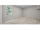 Bright bedroom with neutral carpet, trim and paint and a large window at 1524 Wedgewood Dr, Graham, NC 27253