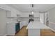 Bright kitchen features white cabinets, stainless steel appliances, and a center island with white countertop at 1524 Wedgewood Dr, Graham, NC 27253