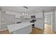 Bright kitchen features white cabinets, stainless steel appliances, and a center island with white countertop at 1524 Wedgewood Dr, Graham, NC 27253