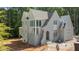 Exterior view of the light grey brick home featuring an arched doorway and abundant windows at 1529 Lake Adventure Ct, Raleigh, NC 27613
