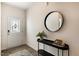 Welcoming foyer with elegant decor, a round mirror, decorative table, wood-look flooring, and an attractive front door at 165 Babbling Creek Dr, Youngsville, NC 27596