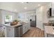 Modern kitchen with granite countertops, stainless steel appliances, a kitchen island, and hardwood floors at 165 Babbling Creek Dr, Youngsville, NC 27596