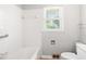 Clean, bright bathroom featuring a white tile tub/shower combo and a window at 1702 Pinecrest St, Burlington, NC 27215