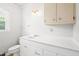 All-white bathroom with modern vanity, white walls, and a window at 1702 Pinecrest St, Burlington, NC 27215