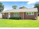 Charming single story brick home with a well-manicured lawn and mature trees at 1702 Pinecrest St, Burlington, NC 27215