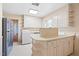 The kitchen has a breakfast bar, updated refrigerator, and access to a laundry area at 1702 Pinecrest St, Burlington, NC 27215