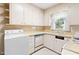 The kitchen features light colored cabinetry and appliances, plus a breakfast bar at 1702 Pinecrest St, Burlington, NC 27215