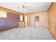 Spacious living room featuring wood paneling, brick accent wall, and plush carpeting at 1702 Pinecrest St, Burlington, NC 27215